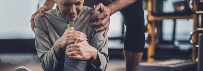 Chiropractic Issaquah WA Knee Pain Lady A woman holding her knee in pain.